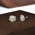 Silver rose stud earrings with screw back closure on a textured dark wood background - Rose Flower Shape Style (A301)