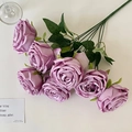 Bouquet of artificial purple roses with seven heads and green leaves on white surface - Purple