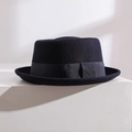Détail d'un chapeau Pork Pie en laine foncée avec ruban gros-grain et nœud décoratif - Bleu marine
