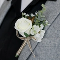 White PE rose boutonniere with golden leaves and twine handle on a grey suit - Cream