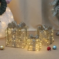 Detailaufnahme goldener leuchtender Weihnachtsgeschenkboxen mit warmen LED-Lichtern - Warmgoldener Paillettenstil (E11485)