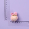 Pink handmade crochet doll charm with bow and pearl detail measured on ruler - MENGSI Pink Bow Dumpling