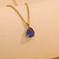 Golden birthstone necklace featuring a brilliant blue teardrop pendant in claw setting - July (Blue)