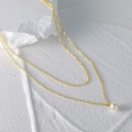 Detail of a double-layered gold chain necklace with a round white pearl pendant - Gold Double Layer-Single Pearl Pendant