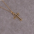 Detailed view of a gold cross pendant with black enamel inlay on a textured gray background - Black Enamel Cross Style (14#)