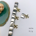 Detailed macro view of a gold plane charm on a silver stainless steel bracelet link - Model 124-Airplane