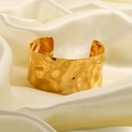 Macro detail of gold textured wide cuff bracelet resting on elegant beige silk fabric - 1087-Handmade Hammered Texture Wide Cuff