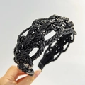 Detail view of the black braided PU leather headband with complex texture and glossy finish - Black