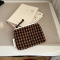 Detailed view of houndstooth coin purse placed on a book for everyday storage - Orange Coffee Small Plaid