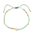 Detalle de una pulsera de cordón tejido con cuentas de colores y una perla natural central - Multicolor Bohemio (QQ401A)