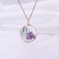 Close-up of glass pendant with blue butterfly and purple dried flowers on gold chain - Gold Purple