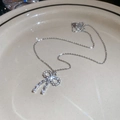 Vue détaillée du collier nœud argenté serti de diamants sur une assiette en céramique - Collier - Argent