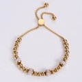 Bracciale regolabile con perline dorate e sfere di cristallo su sfondo bianco - Oro