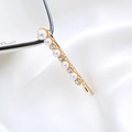 Elegant gold pearl hair clip with rhinestones displayed on white silk fabric background - Pearl Rhinestone Spaced Bobby Pin