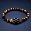 Bracciale in perline di occhio di tigre con corona dorata e pietra nera su fondo di pelle - Occhio di Tigre Opaco