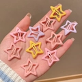 Hand holding macaron-colored star hair clips in soft pink, yellow, and purple tones - Pink Star Clip Set - 10 Pcs