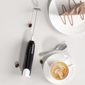 Handheld electric milk frother in black finish with metal whisk and stand for coffee - Black/White