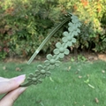 Matte green flower headband with 3D daisy design shown against a natural outdoor background - Green