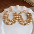 Gros plan détaillé de boucles d'oreilles créoles dorées à perles multicouches - Grandes Créoles Dorées Perles Multicouches (Crochet d'Oreille)