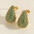 Macro shot of gold teardrop earrings with pave green zirconias and butterfly backs - Green Zirconia