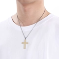 Detail van een tweekleurige goud-zilveren kruiszetting gedragen door een model in wit shirt - Goud (KN199330-KLHQ)