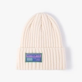 Chic off-white knitted beanie with authentic signature patch and ribbed wool texture - One Size / Cream