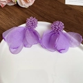 Primer plano de pendientes de flores de tela violeta con cuentas en plato de cerámica - Morado