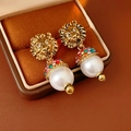 Close-up of vintage lion head earrings with colorful rhinestones and white pearls - Gold-White