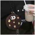 Détail d'une pochette biscuit en peluche avec visage rigolo et cordon tressé sur pull - Style Biscuit Café Noir Refus