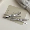 Set of two silver metallic leopard print bow hair clips on a minimalist beige card - Silver Hair Clip