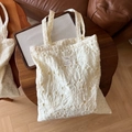Primer plano del bordado floral y la etiqueta de tela en un bolso tote de algodón crema - Bordado Floral Calado