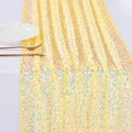 Golden mermaid sequin table runner with iridescent shimmer on white fabric backdrop - Champagne