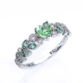 Vista macro del anillo de plata S925 con gema verde de corazón y grabados de precisión - US 7 / Verde