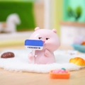 Pink Capybara resin ornament holding blue sign for car dashboard and desk decoration - Innocent Pig (1188-35)