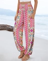 Close-up of bohemian pink high-waisted floral pants on a beach with sea backdrop - S / Rose Red