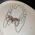 Detailed macro view of double-layered pearl necklace with silver butterfly pendants - Silver-White Butterfly Tassel Style