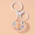 Detail of creative lifebuoy keychain with summer elements and safety text on warm background - White