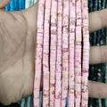 Hand holding multiple strands of pink natural stone disc beads with marble texture - Imperial Jasper 18