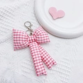 Detailed close-up of a pink checkered fabric bow keychain with metal clasp and keyring - Pink Plaid