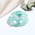 Detailed macro of green and white gradient resin chain ring on cream silk fabric - Mixed Green