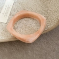 Macro shot of marble textured resin square bangle in peach orange with a glossy finish - Rounded Square Marble Texture Style / Pink with Coffee Pattern