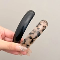 Elegant black and leopard print spring hair clips shown in hand with glossy finish - Glossy Black + Light Tortoiseshell