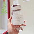 Dettaglio della tazza da tè in vetro con custodia in pelle beige e scritta One Cup - 550ml / Bianco