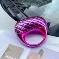 Macro detail of purple metallic acrylic ring with quilted lattice pattern on magazine - Purple