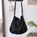 Detail of a large black shoulder bag with lace butterfly print hanging in a home setting - Black Background Large Butterfly