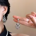 Gros plan de boucles d'oreilles bohèmes en argent avec fleurs et perles violettes - Style 7 Tige en Argent Argent Noir Fusil Goutte d'eau
