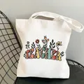 White canvas tote bag with colorful teacher leopard print lettering on a modern chair - Style C13