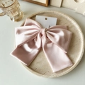 Nahaufnahme der rosa Satin-Haarspange mit großer Schleife auf einem Steintablett - Rosa