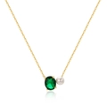 Detailed shot of golden chain necklace with emerald oval gemstone and white pearl pendant - Emerald Green - Gold