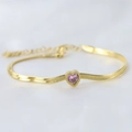 Macro view of a 14K gold-plated snake chain bracelet with a pink heart-shaped crystal - Bright Pink